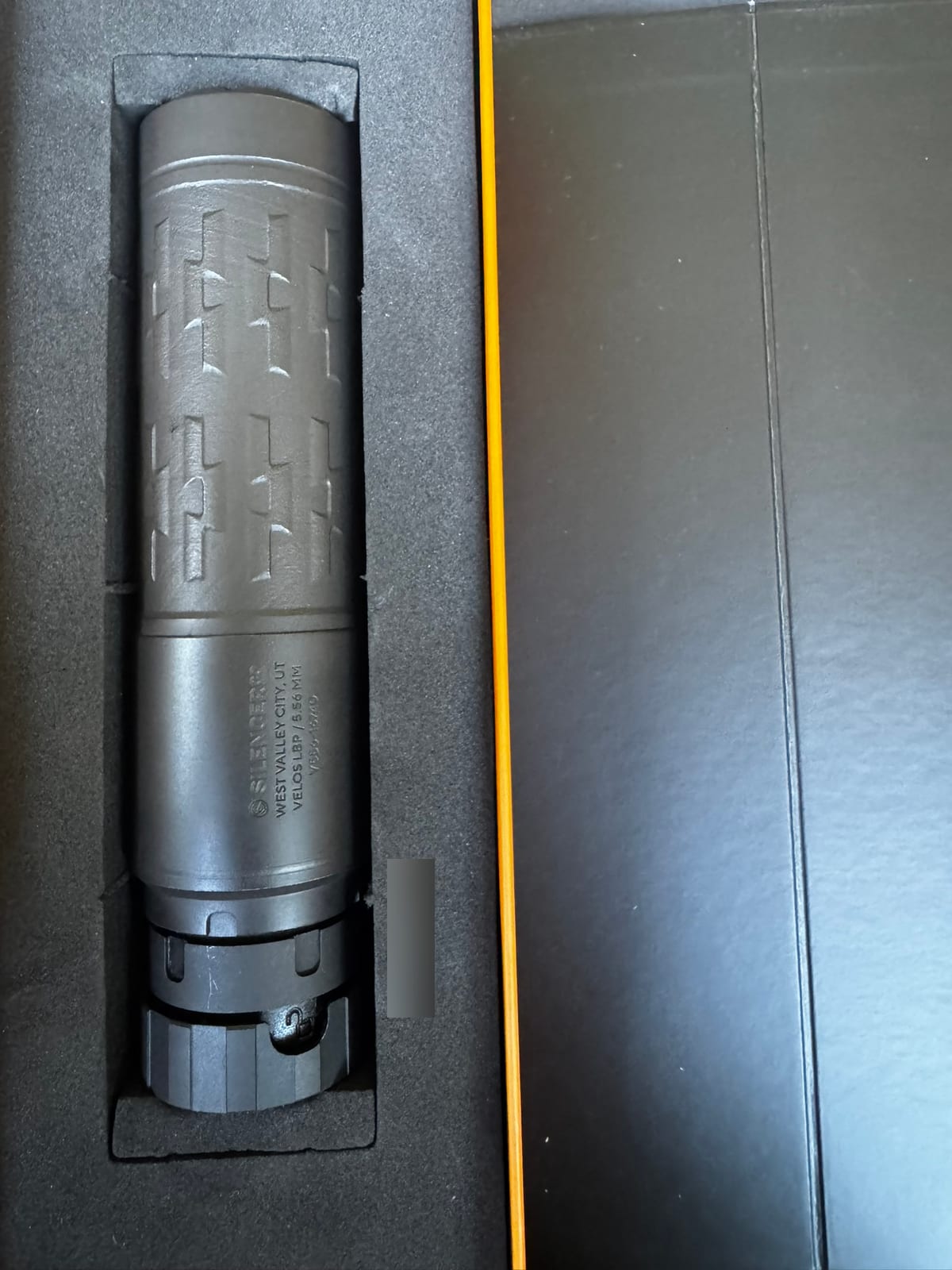 The Velos LBP lying in the foam of its shipping box, with the roll mark reading SilencerCo, West Valley City UT, Velos LBP, 5.56mm. The serial number below it is blurred out.