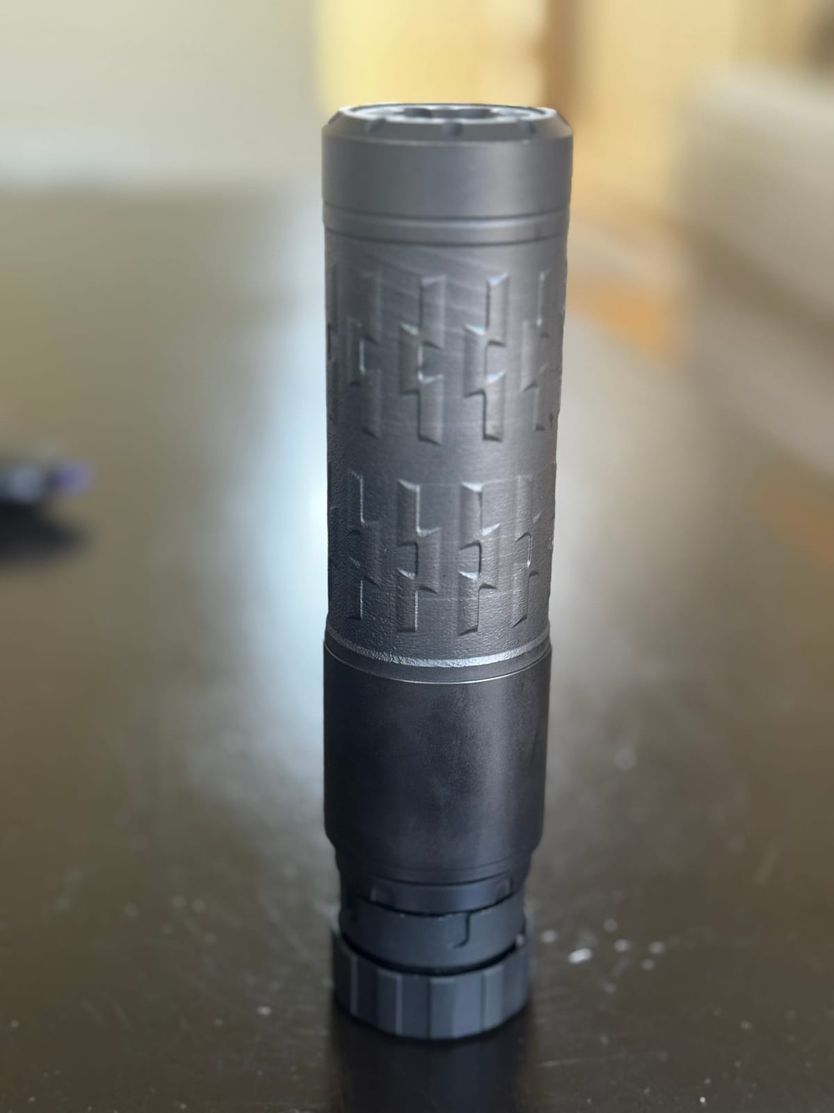 The Velos LBP standing on end on a dark table, showing the printed Inconel body texture and the ASR mount collar at its base.
