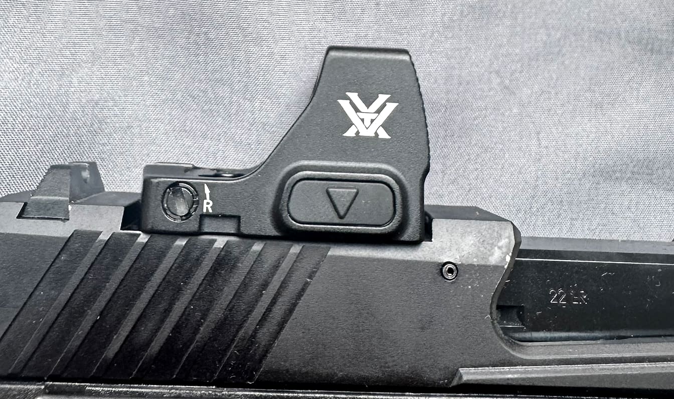The brightness control buttons and battery compartment on the side of the Vortex Defender-CCW.