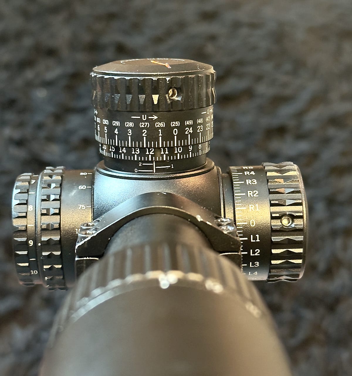 Close view of the Viper PST turret cluster showing the elevation turret graduations, the side parallax knob marked with yardages, and the windage turret marked R1 through R4 and L1 through L4.